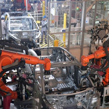 Image of an assembly line where two robots are coordinating the production of an automobile frame.