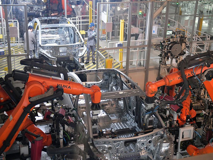 Image of an assembly line where two robots are coordinating the production of an automobile frame.