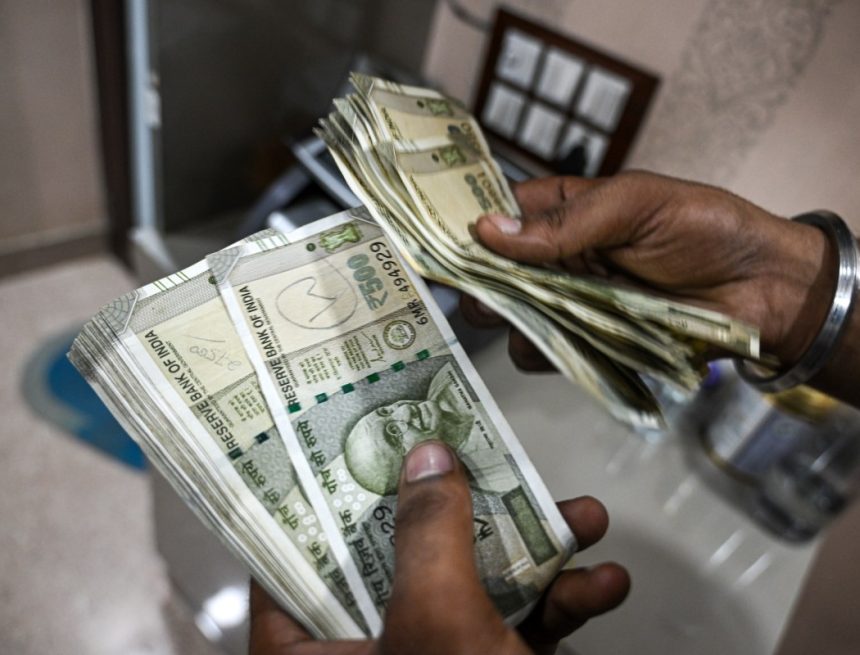 An employee counts 500 rupee banknotes at a currency exchange in New Delhi, India, on Saturday, Aug. 30, 2025. The Indian rupee slumped to a record low versus the dollar on concern that 50% US tariffs will hurt the country's economic growth and corporate earnings.