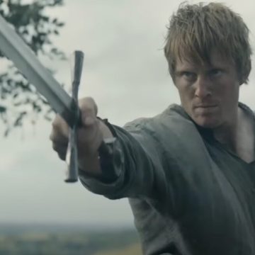 man in humble medieval shirt wielding a sword before an unseen enemy
