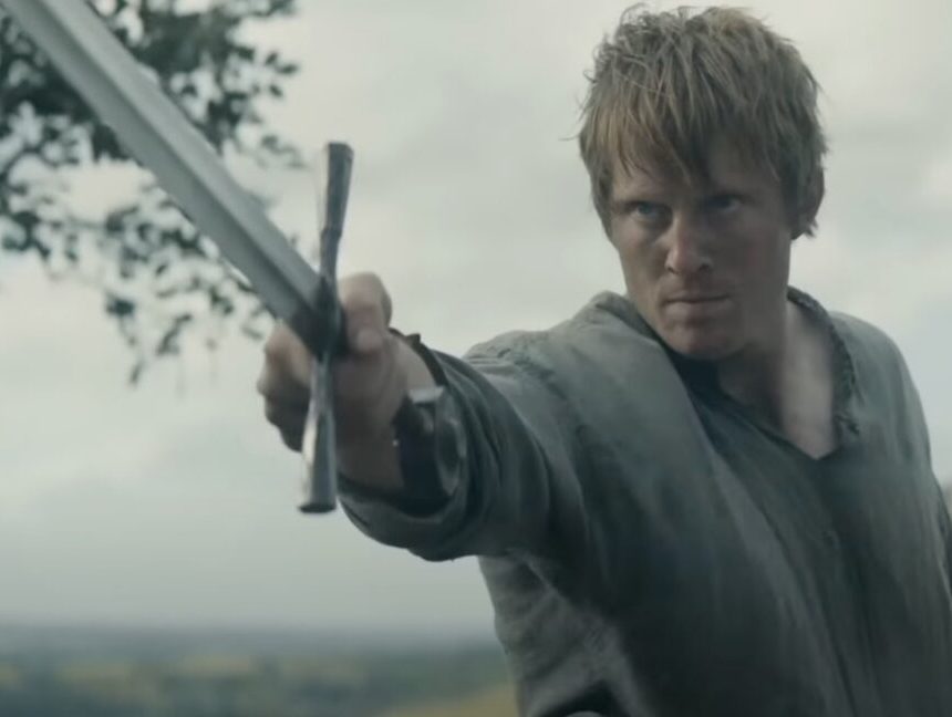 man in humble medieval shirt wielding a sword before an unseen enemy