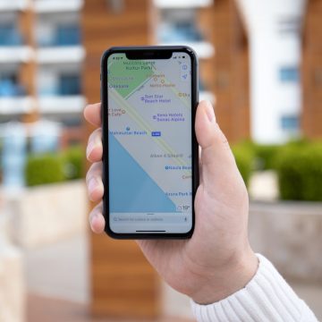 Ads might be coming to Apple Maps next year Man hand holding iPhone 11 with Apple map on screen