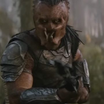 A Predator on an alien world brandishing a weapon