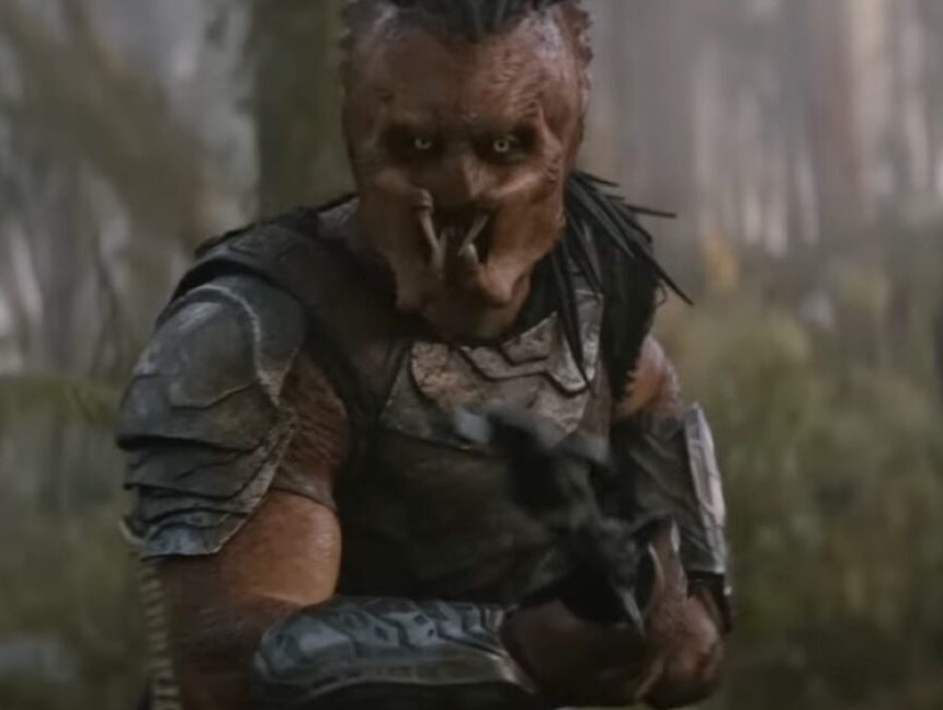 A Predator on an alien world brandishing a weapon