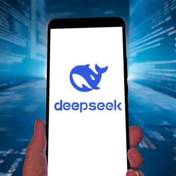 DeepSeek logo on a smartphone against a blue streaming-code tech-ish background.