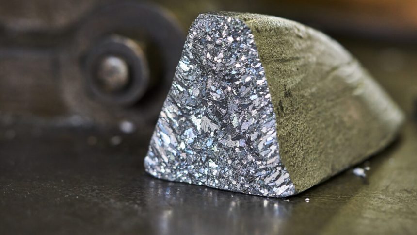 An oddly shaped hunk of metal, with a dull, oxidized color on most surfaces, but one showing freshly exposed material that has a silvery glint.