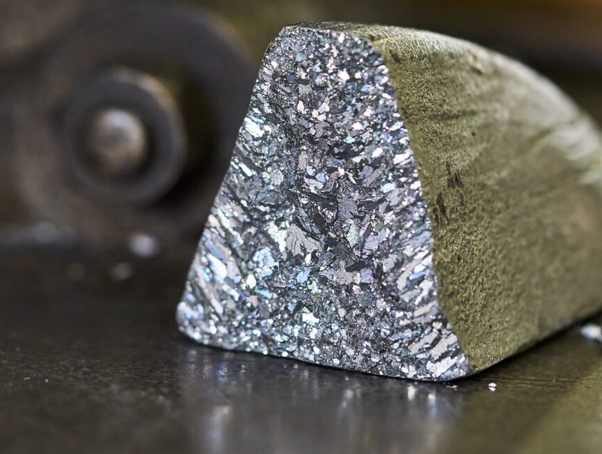 An oddly shaped hunk of metal, with a dull, oxidized color on most surfaces, but one showing freshly exposed material that has a silvery glint.