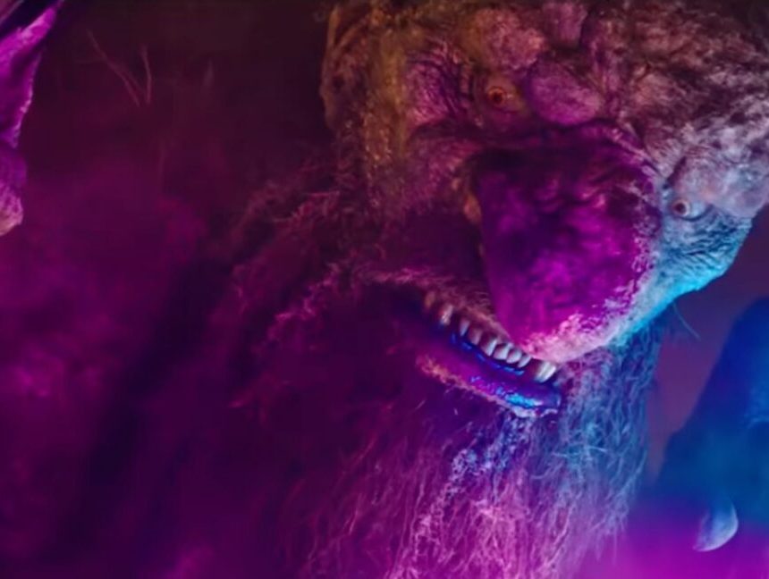 closeup of a giant troll with purple and pink nightclub lights playing off his boulder-like face.