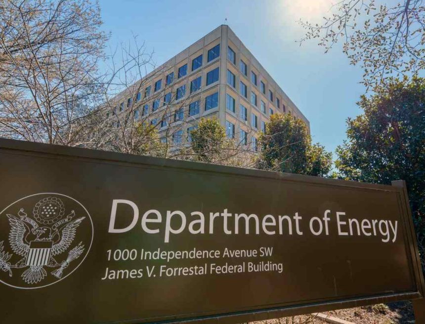 The U.S. Department of Energy building is seen behind a sign marking the location of the agency's headquarters.