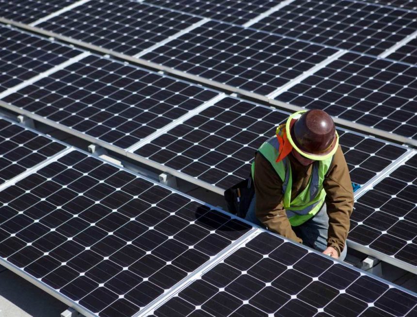 A man inspects solar panels.