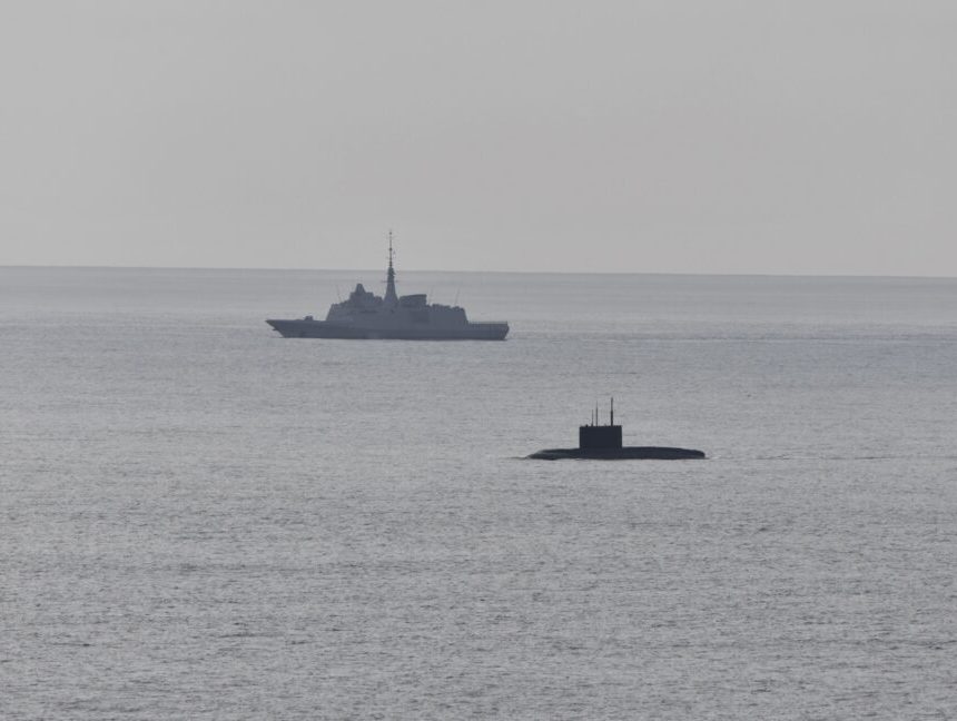 A French Navy vessel watches the surfaced Russian sub Novorossiysk this week.