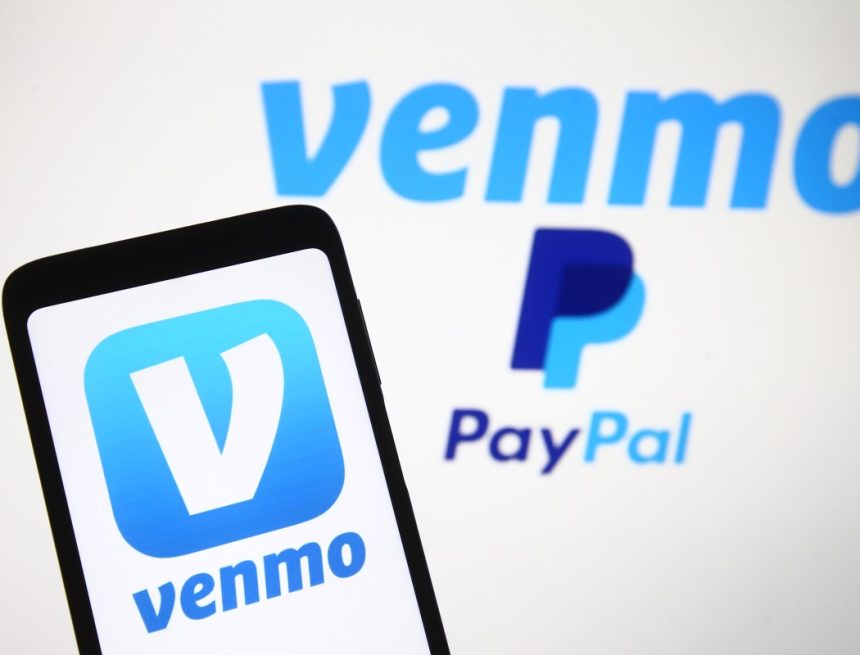 Venmo logo, a mobile payment service of PayPal is seen displayed on a smartphone and a PC screen.