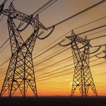 The silhouette of the high voltage power lines during sunset.