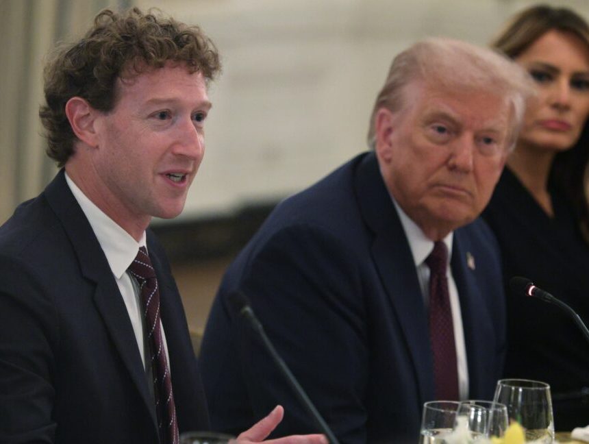 Mark Zuckerberg, Donald Trump, and Melania Trump sit next to each other at a table while Zuckerberg speaks into a microphone.