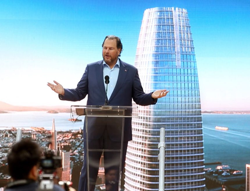 Marc Benioff standing at a podium in front of a backdrop of Salesforce Tower.