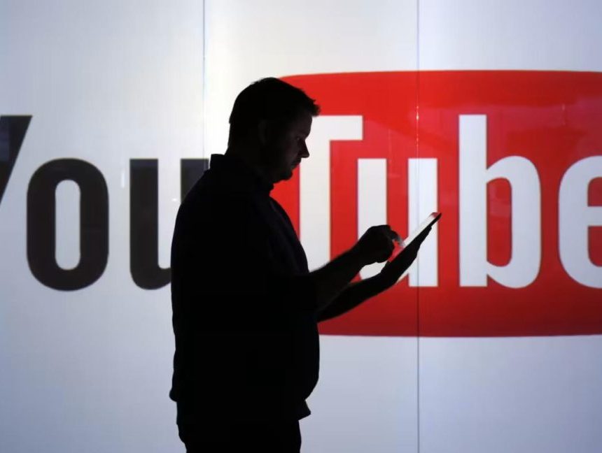 Man using phone in front of YouTube logo