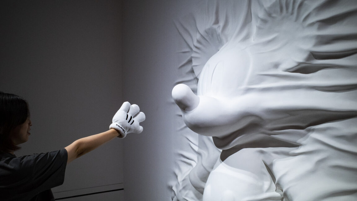 A visitor examines a sculpture at "Mickey: The True Original & Ever Curious" exhibition on July 26, 2022 in Beijing, China.