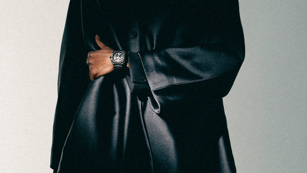 Bell & Ross satin-finished black ceramic watch with 41mm case; Dior blended silk scuba canvas coat and wool twill pants.